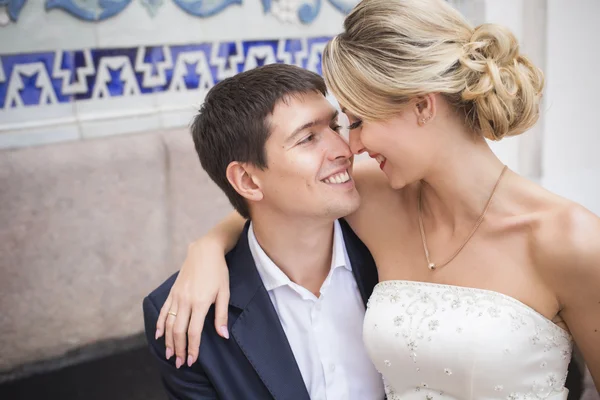 Молодая пара целуется в свадебном платье. Букет невесты с красными розами — стоковое фото