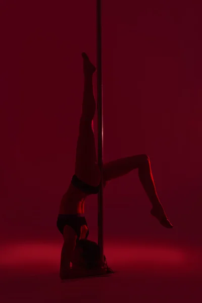 Young beautiful brunette girl doing pole dancing exercise. isolated — Stock Photo, Image