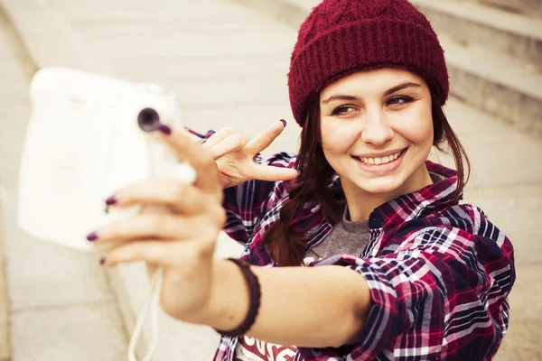 Esmer kadın basamaklarında oturan ve retro kamera sokak selfie alarak hipster kıyafeti. tonlu görüntü — Stok fotoğraf