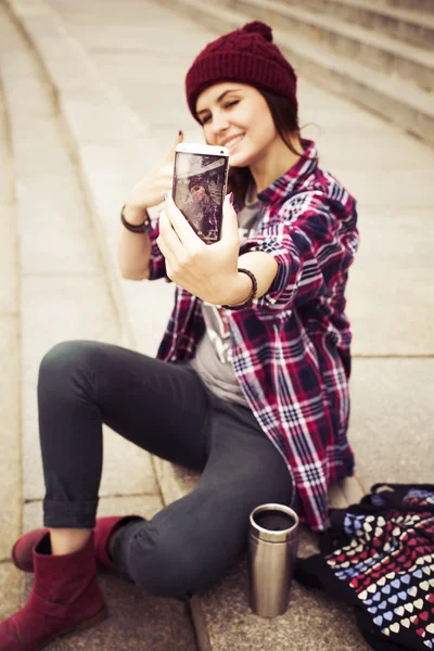 esmer kadın basamaklarında oturan ve retro kamera sokak selfie alarak hipster kıyafeti. tonlu görüntü