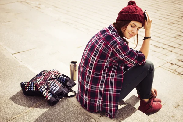 Μελαχρινή γυναίκα με στολή hipster κάθεται σε βήματα στο δρόμο. τονισμένο εικόνας. αντίγραφο χώρου — Φωτογραφία Αρχείου