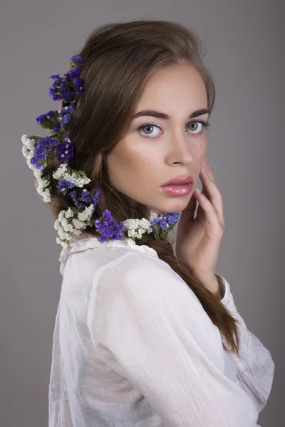Vacker brunett flicka med naturlig make up och blommor i håret — Stockfoto