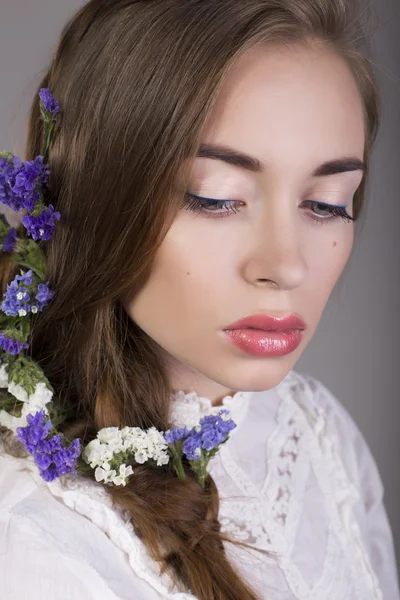 Hermosa chica morena con maquillaje natural y flores en el pelo —  Fotos de Stock