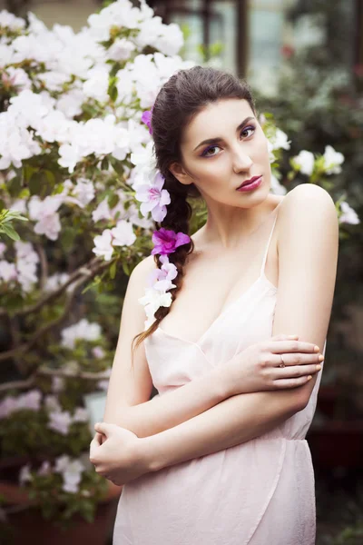 Retrato de una hermosa mujer morena en vestido rosa y maquillaje colorido al aire libre en el jardín de azalea —  Fotos de Stock