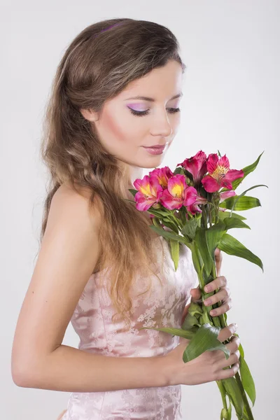 Mooi blij meisje geven een wild orchid violette bloemen — Stockfoto