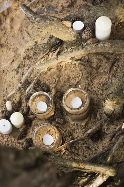 Belo lugar romântico decorado para um encontro com frascos cheios de velas em pé em uma areia — Fotografia de Stock