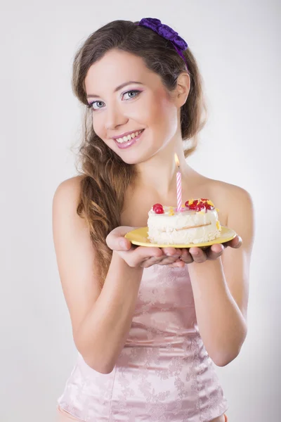 Hermosa chica feliz proponer un pastel de cumpleaños con vela — Foto de Stock