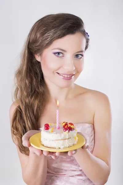 Hermosa chica feliz proponer un pastel de cumpleaños con vela — Foto de Stock