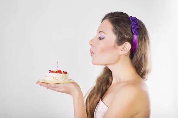 Menina feliz bonita propor um bolo de aniversário com vela — Fotografia de Stock