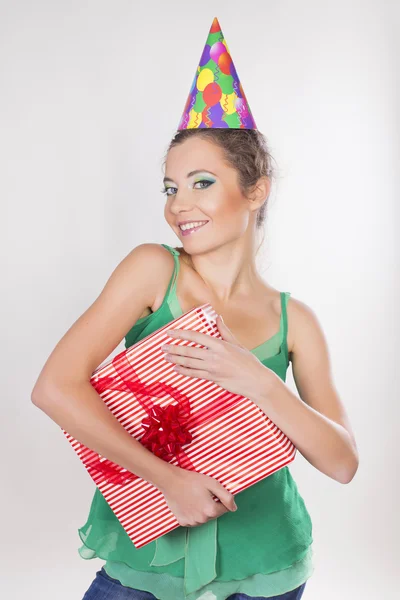 Brünette Frau mit Geburtstagskappe mit Geschenken und Lächeln — Stockfoto
