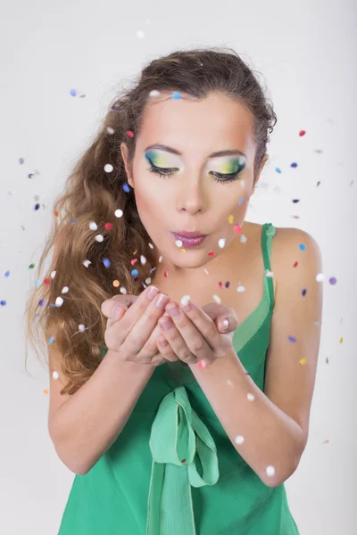 Brunette vrouw wegwaaien de confetti op haar verjaardagspartij — Stockfoto