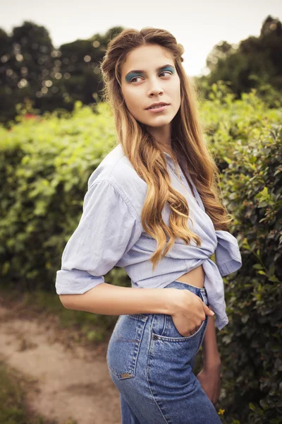 Mulher loira sensual bonita com maquiagem e cabelo encaracolado refrigeração no parque. Ao ar livre . — Fotografia de Stock