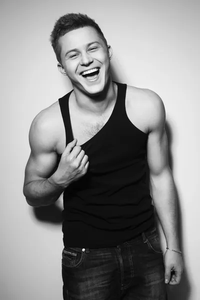 Handsome gorgeous young man in shirt indoor smiling. Black and white — Stock Photo, Image