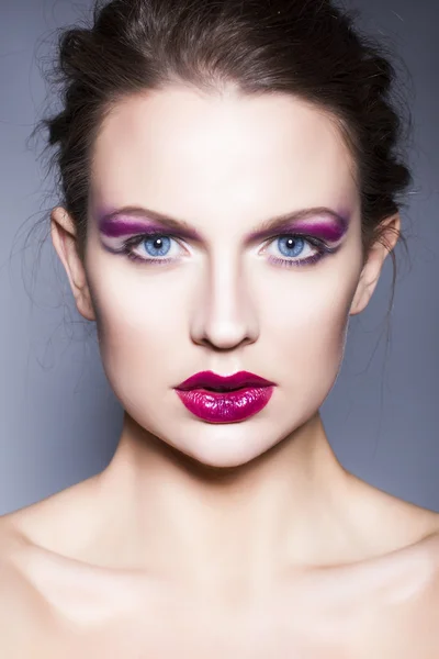 Hermosa mujer morena con creativo maquillaje violeta sombras de ojos labios rojos completos, ojos azules y pelo rizado —  Fotos de Stock