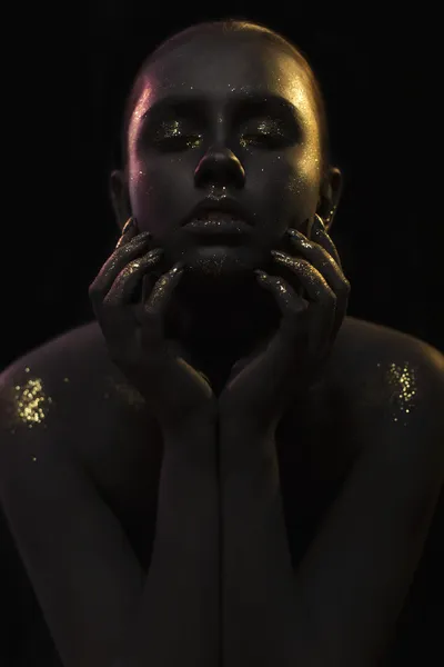 Gros plan portrait d'une femme dans une pose de symétrie sur fond noir avec les paillettes et scintillements sur toute la peau noire — Photo