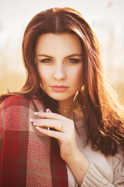 Brunette woman outdoors in check pattern plaid drinking tea and looking down near the lake Royalty Free Stock Photos