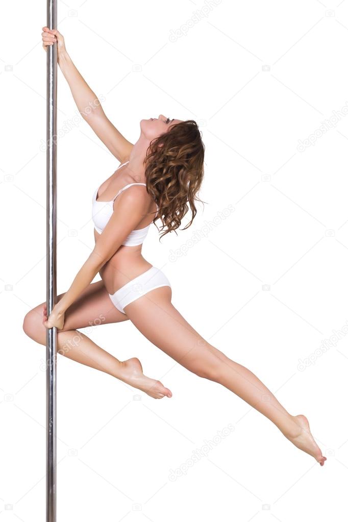 Young beautiful brunette girl doing pole dancing exercise. isolated on white