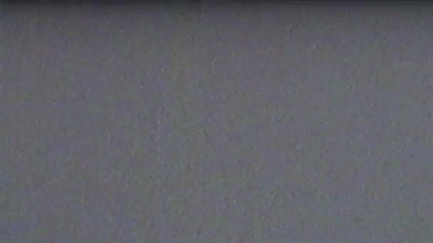 VHS. Grijze achtergrond van het CRT scherm. Effectonderbreking van het tv-signaal. VHS schudden, flikkeren, defecten, lawaai en artefacten op grijs tv-scherm. Retro jaren 80, jaren 90. — Stockvideo