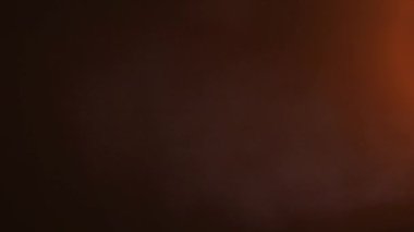 Kaplama ve geçiş. Işığın dikey hareketi sızar ve parlar. Amber Light Kara Arkaplanda Sızıntı Yapıyor. Arkaplan için mercek parlamaları.