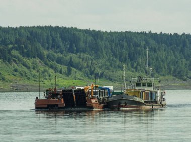 30.07.2021 Rusya. Krasnoyarsk bölgesi. Yenisei Nehri 'nde bir mavnası olan ST-701 motor gemisi kuzey teslimatını gerçekleştirir..