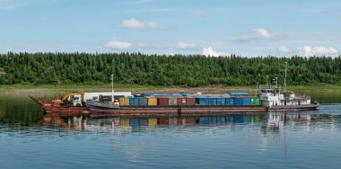 30.07.2021 Rusya. Krasnoyarsk bölgesi. Yenisei Nehri 'nde bir mavnası olan ST-701 motor gemisi kuzey teslimatını gerçekleştirir..