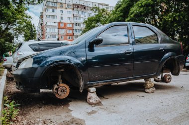 Tekerlekleri olmayan bozuk bir yolcu vagonu tuğlaların üzerinde duruyor.