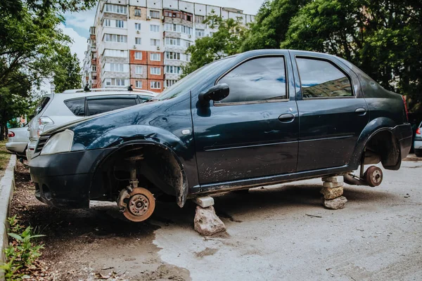 Tekerlekleri olmayan bozuk bir yolcu vagonu tuğlaların üzerinde duruyor.