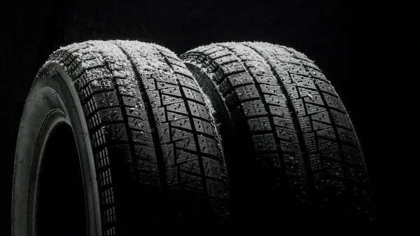 Winter Car tires with snow close-up wheel profile structure on black background — Stock Photo, Image