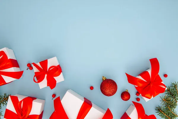 Composizione natalizia, regali, rami di abete, decorazioni rosse su sfondo blu, inverno, concetto di nuovo anno, posa piatta, spazio copia — Foto Stock