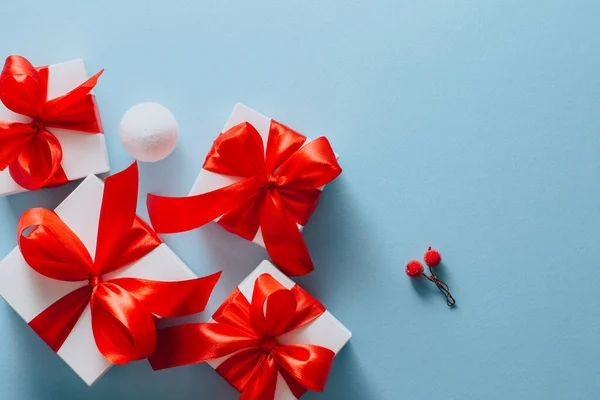Scatole regalo su sfondo blu cartolina di auguri vacanze concetto, regalo scatola bianca legato con nastro rosso — Foto Stock