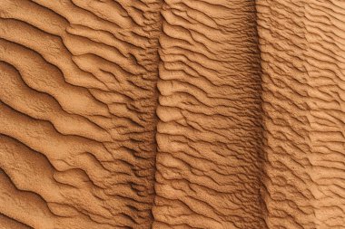 Çöldeki kumun dokusu. Dalgalı kum arka planı. Üst görünüm