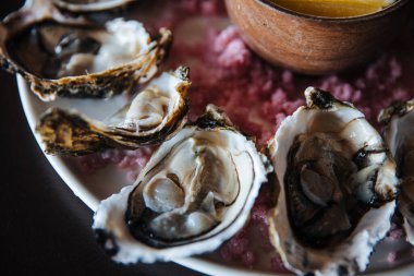 Tabakta taze istiridye, istiridyelerle servis edilen masa, restoranda limon. Gurme yemekleri.