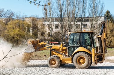 Dneprorudnoe / Ukrayna - Nisan 08 2020: Bir traktör kovadan çakıl döktü