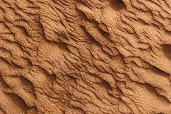 Çöldeki kumun dokusu. Dalgalı kum arka planı. Üst görünüm