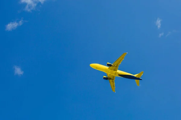 Желто-синий пассажирский самолет летает в голубом небе, концепция воздушного транспорта, эвакуация населения — стоковое фото