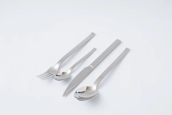Conjunto de talheres de aço inoxidável, faca, colher, garfo, colher de chá em um fundo branco, espaço de cópia — Fotografia de Stock