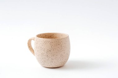 İzole edilmiş beyaz arka planda boş bej kahve seramik bardağı, kes.