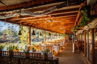 Restoranın iç kısımlarında. Yakınlarda ahşap mobilyalar ve göl var..