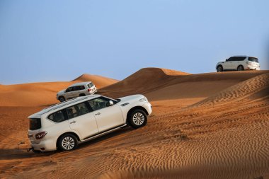 Dubai, Birleşik Arap Emirlikleri - 01 Temmuz 2021: Kum çölünde yarış. Yarış yarışı çölü. Araba toz bulutlarıyla yoldan çıkıyor. Yabanda engellerle yarışan off road aracı