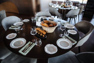 Çok güzel organize edilmiş bir etkinlik. Konuklar için yuvarlak masa ziyafeti, boş tabaklar, bardaklar, çatallar ve peçetelerle süslenmiş yuvarlak masa. Zarif bir yemek masası. 