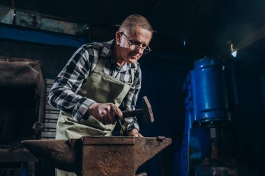 Usta bir demirci demirden bir çekiçle vurur..