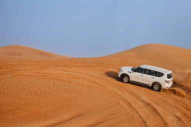 Dubai, Birleşik Arap Emirlikleri - 01 Temmuz 2021: Kum tepelerinin üzerindeki Arap Çölü 'nde araba yolculuğu. Çölde sıcak bir gün.