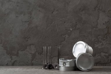 Beton gri zemin üzerinde yeni pistonlar ve vanalar seti, araba tamir parçaları, kopyalama alanı