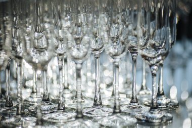 Restoranda bir grup boş ve şeffaf şampanya kadehi. Barmen tarafından şampanya için hazırlanmış temiz bardaklar. Etkinlik hazırlığı için servis, içki için boş bardaklar..