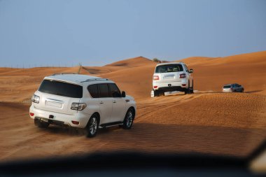 Dubai, Birleşik Arap Emirlikleri - 01 Temmuz 2021: Kum çölünde yarış. Yarış yarışı çölü. Araba toz bulutlarıyla yoldan çıkıyor. Yabanda engellerle yarışan off road aracı