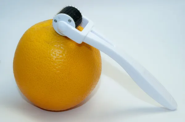 Апельсин с дермороллером — стоковое фото