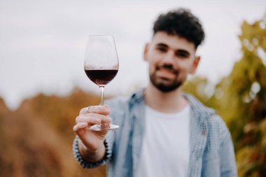 Üzüm bağında bir bardak şarabı olan bir adam. Kendi şaraphanesinde genç bir çiftçi. Bir bardak kırmızı şaraba bakan adam..