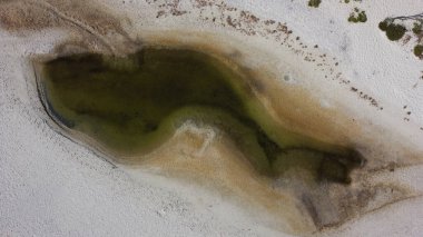 Aerial view of small shallow lake among white sand on Dzharylhach island