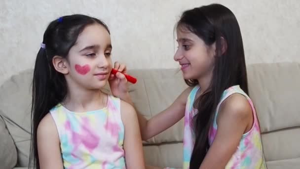 Chicas jóvenes felices con el corazón rojo en la pintura de la cara San Valentín maquillaje — Vídeo de stock