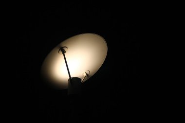 Gece boyunca bir dizayn lambasının gölgesi.